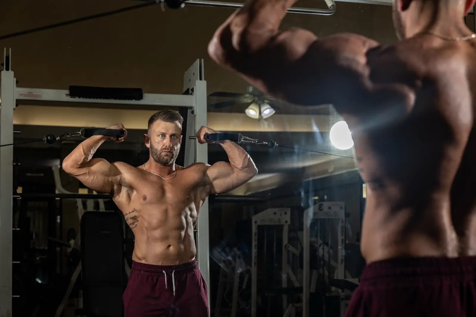 Double-biceps pose in the gym mirror